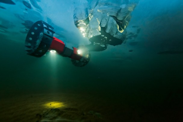 Un rover amphibie évolue sous la glace du lac Sukok, lors d’un test en Alaska. Des bulles de méthane et d’autres composés témoignent que la vie est présente dans ces eaux. © Mark Thiessen